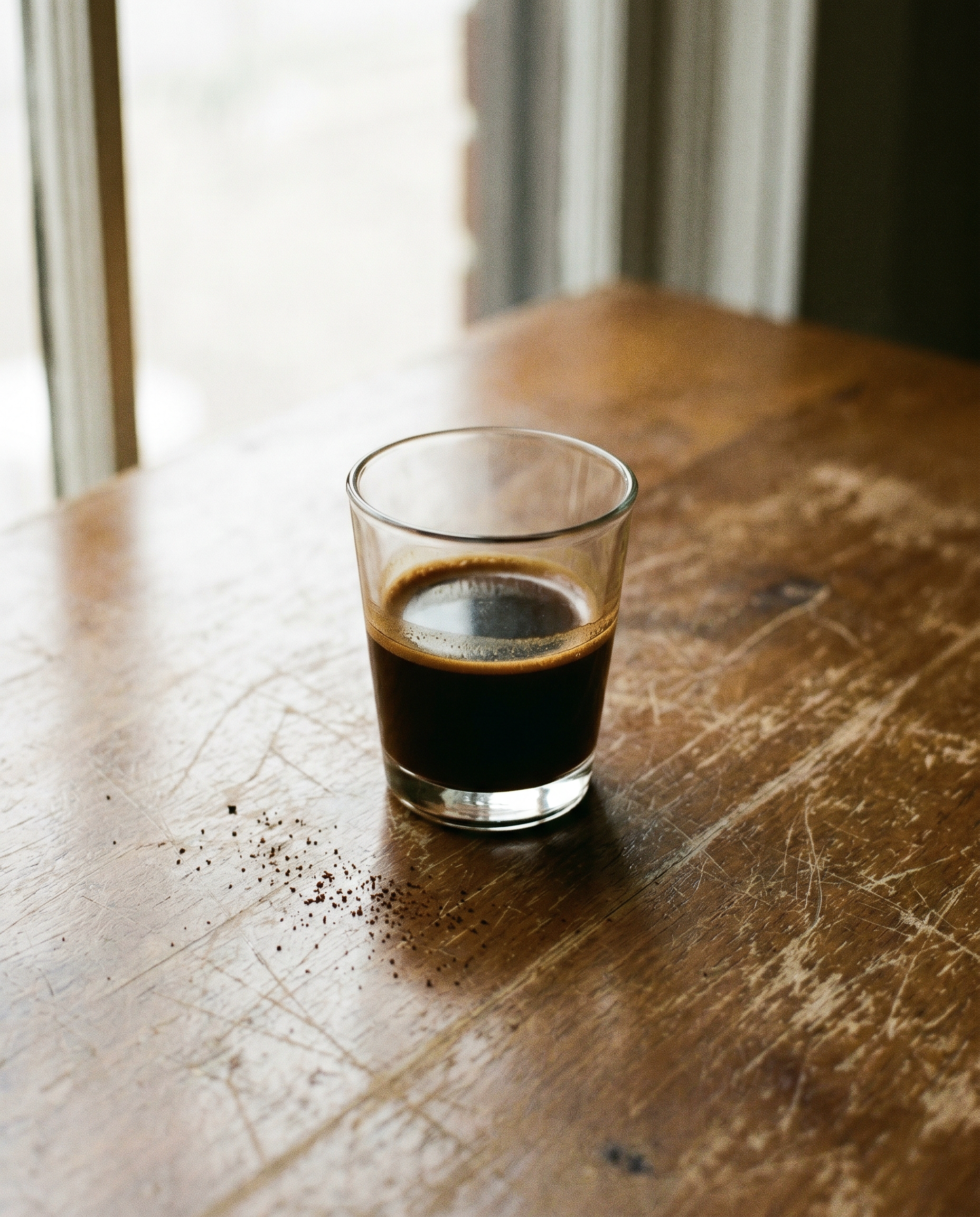 Espresso ohne Crema in einem kleinen Glas auf Holz — Diagnose wenn die Crema fehlt